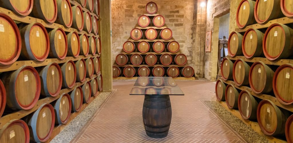Barrels in a wine cellar Wooden barrels and a table in a wine cellar