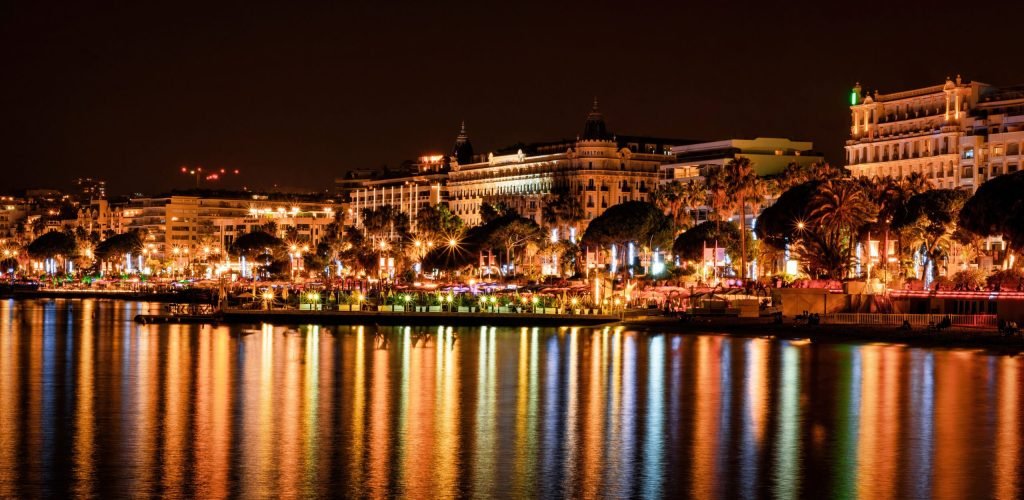 View of Cannes at night, France View of Cannes, France at night. Embankment street, buildings, nightlights, reflections